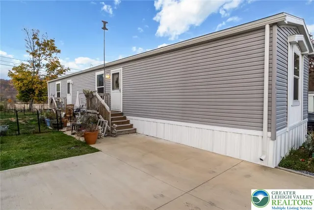 a view of a house with a yard and potted plants
