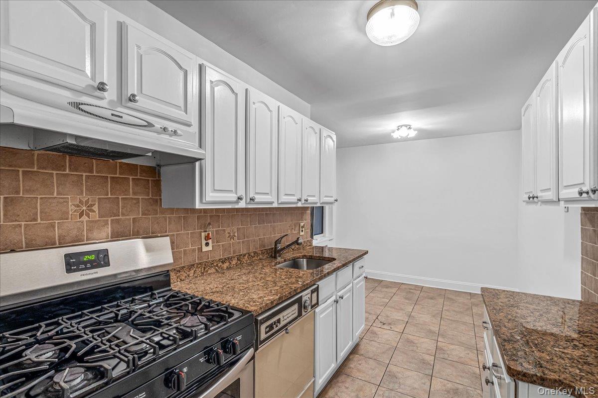 35-30 73rd Street, Unit 1F Queens, NY 11372 - Photo 11 of 24 a kitchen with granite countertop a stove and a sink