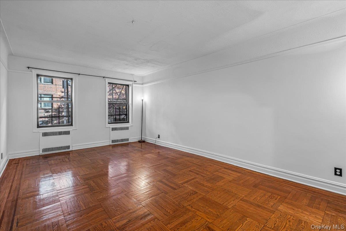 35-30 73rd Street, Unit 1F Queens, NY 11372 - Photo 19 of 24 an empty room with wooden floor and windows