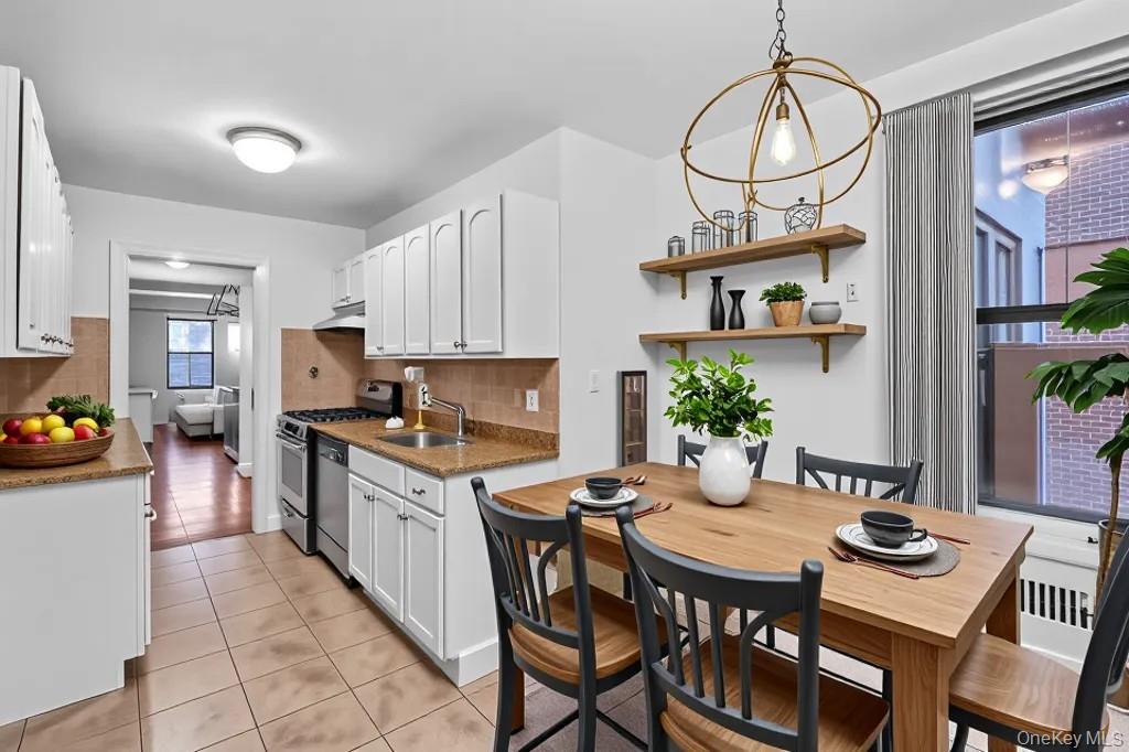 35-30 73rd Street, Unit 1F Queens, NY 11372 - Photo 5 of 24 a kitchen with stainless steel appliances granite countertop a stove a kitchen island a dining table and chairs with wooden floor