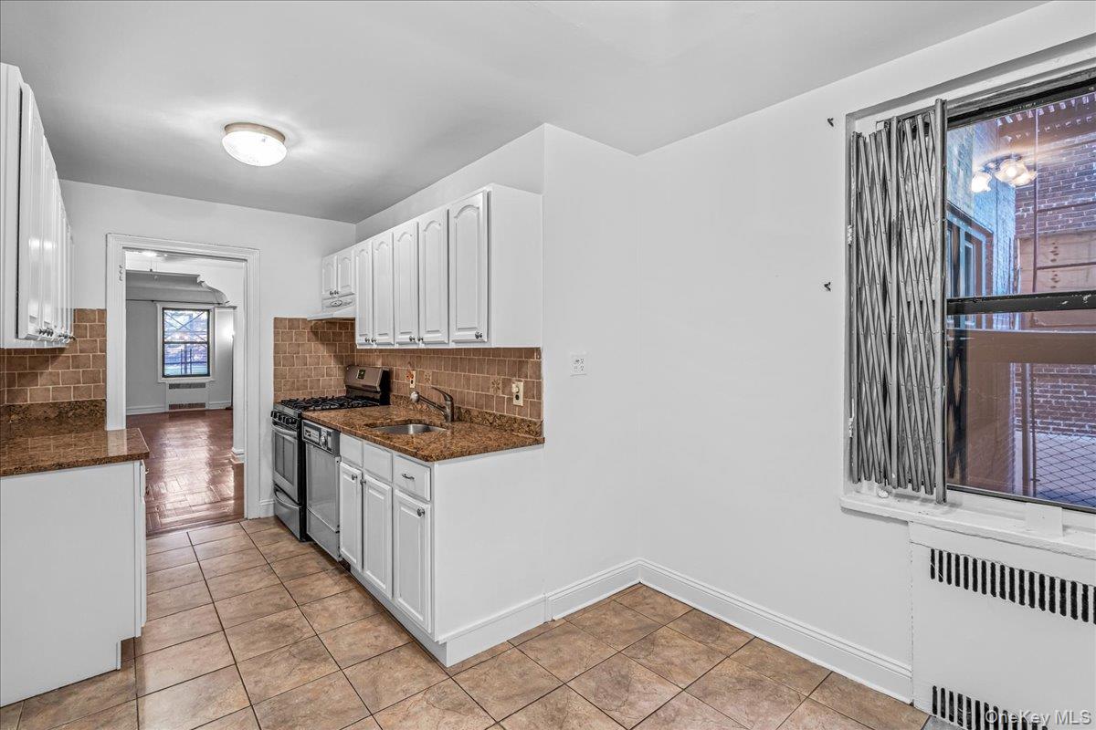 35-30 73rd Street, Unit 1F Queens, NY 11372 - Photo 6 of 24 a kitchen with stainless steel appliances a stove a refrigerator and cabinets