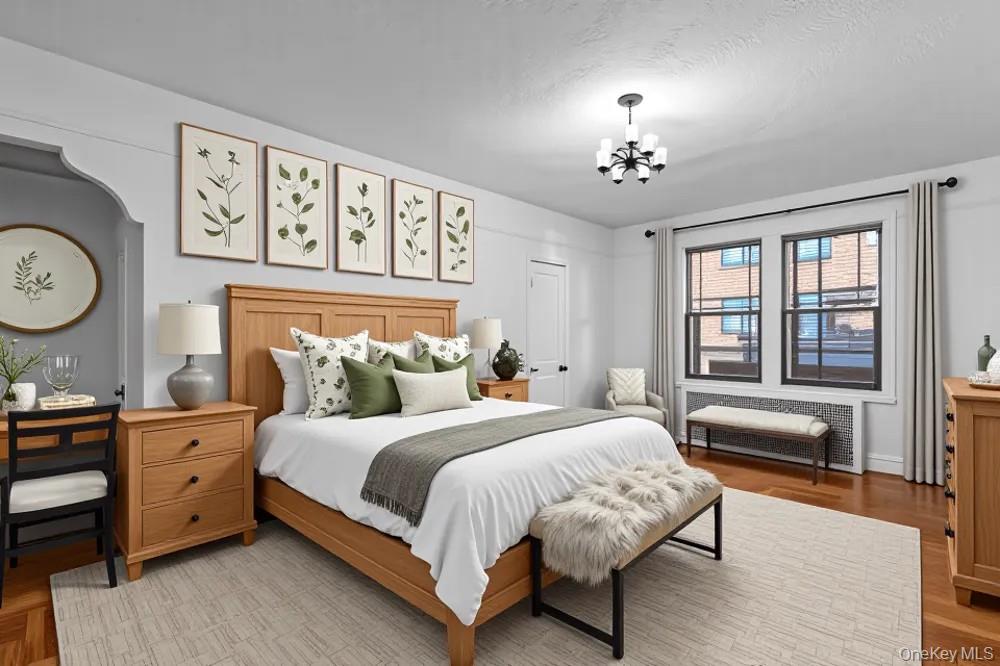 35-30 73rd Street, Unit 1F Queens, NY 11372 - Photo 9 of 24 a bedroom with a large bed and a chandelier