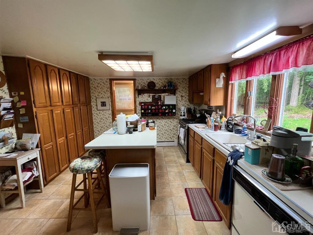 21 White Pine Road North Brunswick, NJ 08902 - Photo 16 of 33 a kitchen with stainless steel appliances kitchen island granite countertop a stove a refrigerator a sink dishwasher and a dining table with chairs