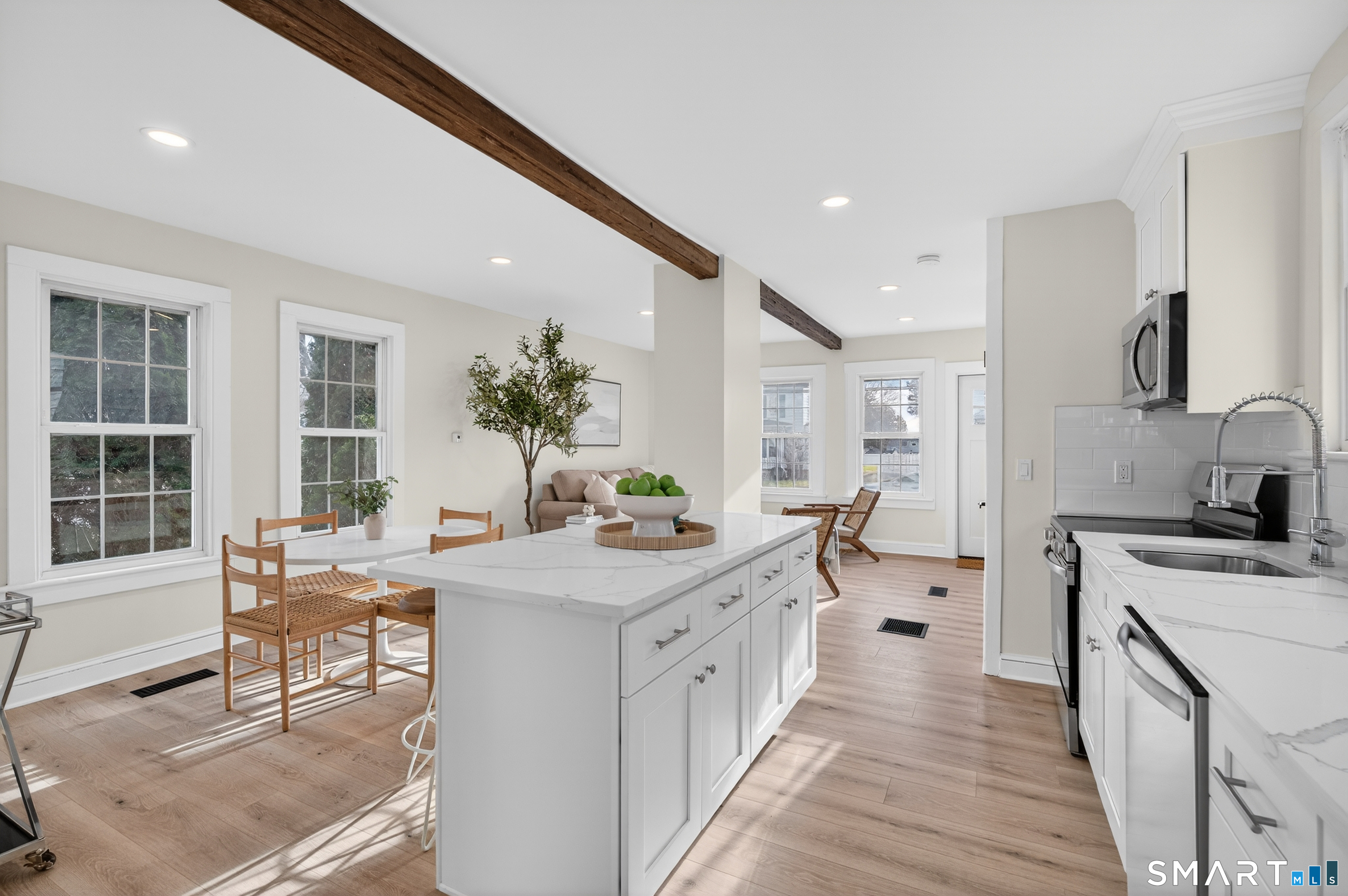 190 West Main Street Milford, CT 06460 - Photo 13 of 28 a large white kitchen with a stove a sink a window and wooden floor