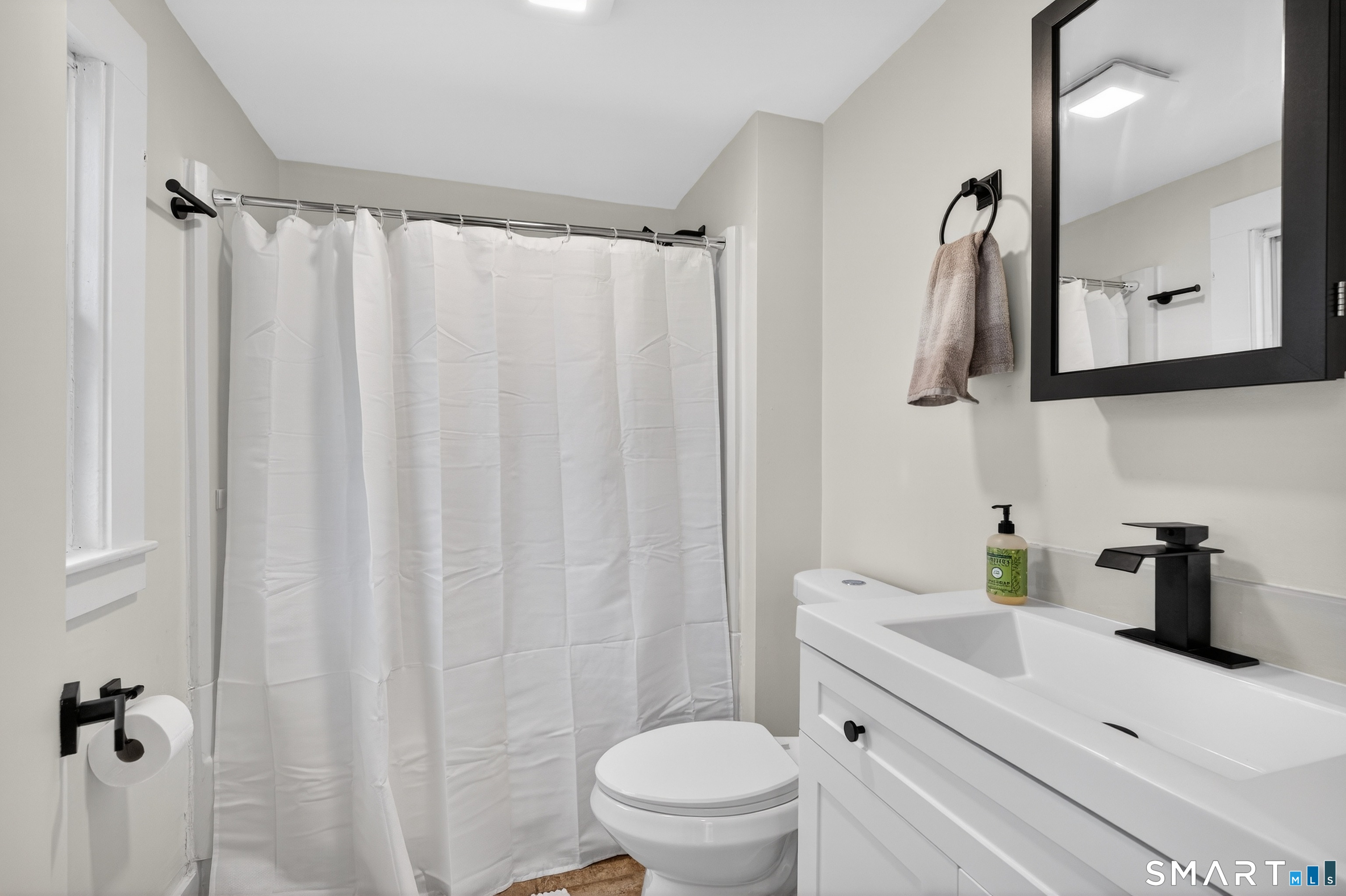 190 West Main Street Milford, CT 06460 - Photo 18 of 28 a bathroom with a sink a toilet and shower curtain