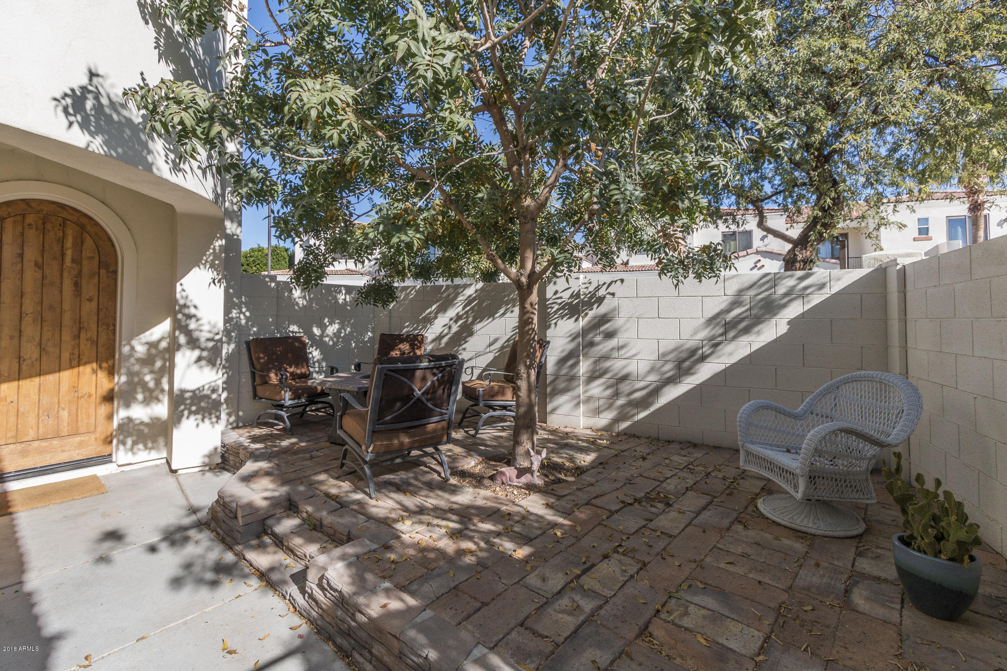 1750 East Ocotillo Road, Unit 23 Phoenix, AZ 85016 - Photo 2 of 27 a backyard of a house with table and chairs