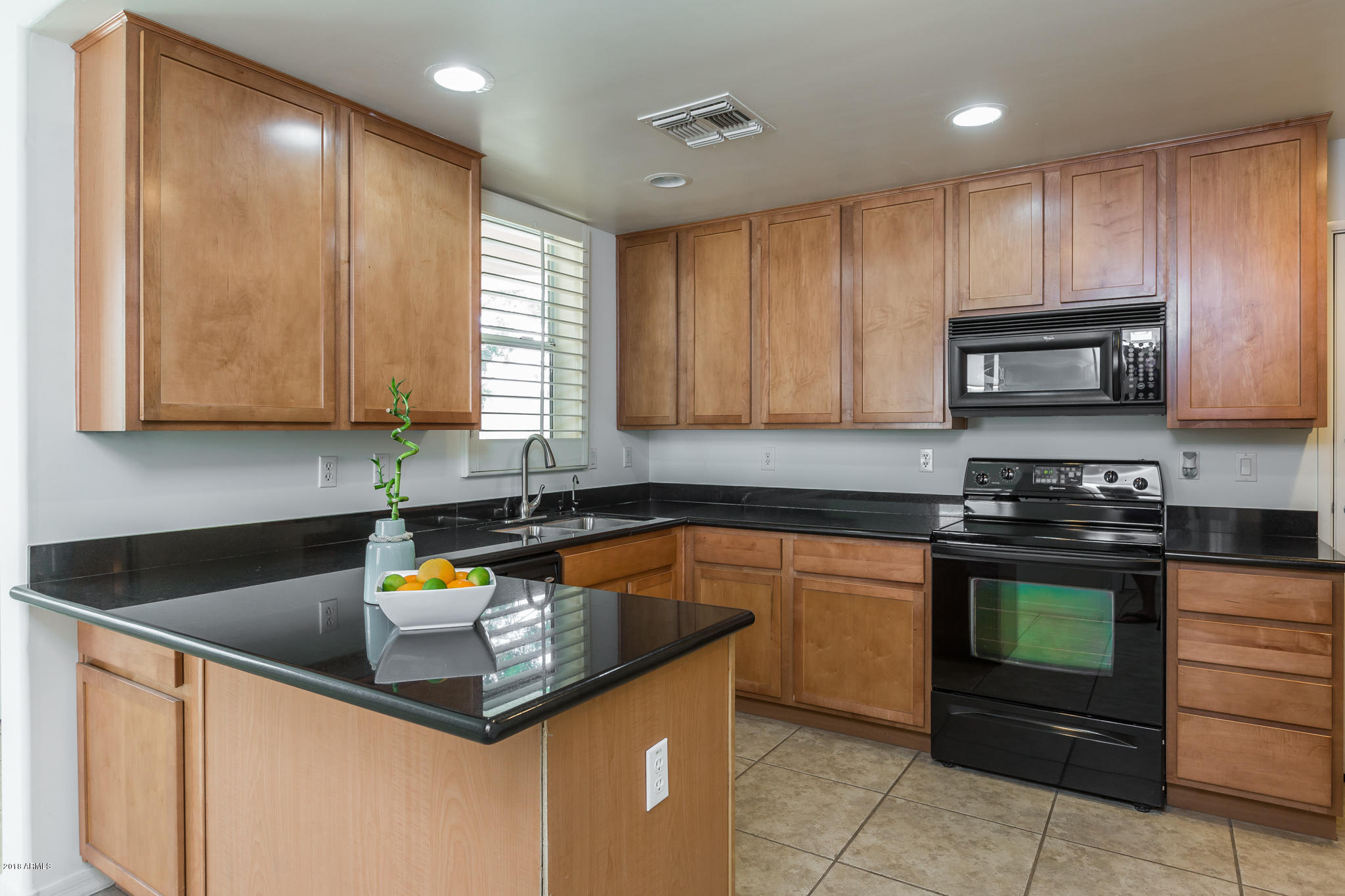 1750 East Ocotillo Road, Unit 23 Phoenix, AZ 85016 - Photo 7 of 27 a kitchen with stainless steel appliances granite countertop wooden cabinets a stove a sink and dishwasher