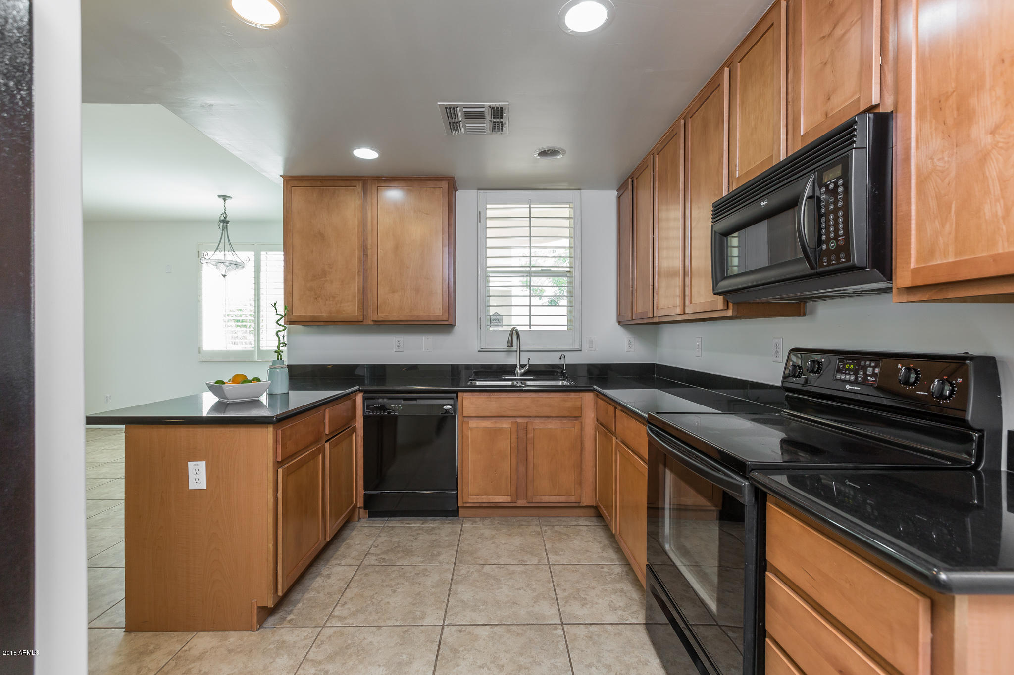 1750 East Ocotillo Road, Unit 23 Phoenix, AZ 85016 - Photo 8 of 27 a kitchen with stainless steel appliances granite countertop a stove a sink and a microwave