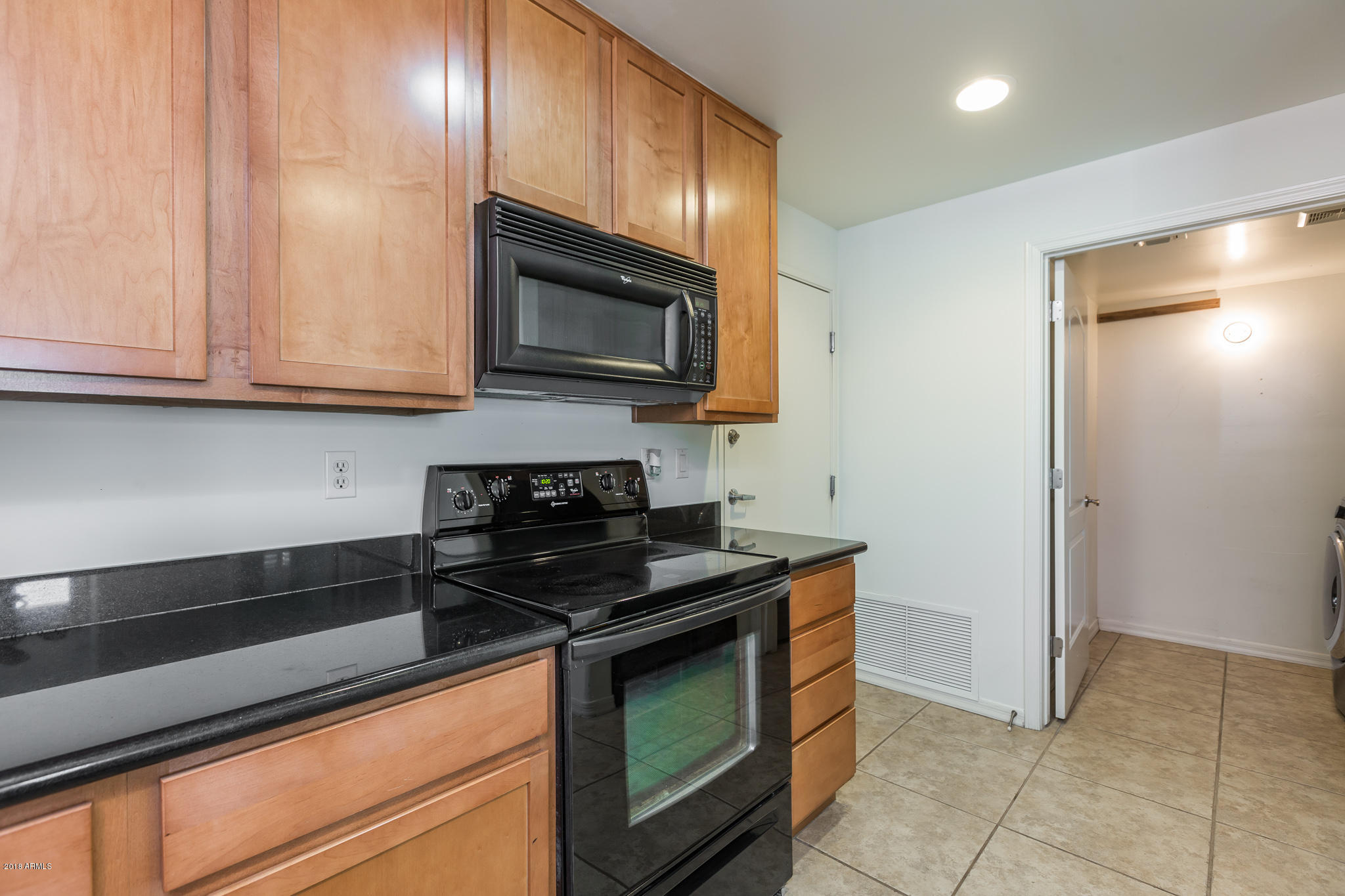 1750 East Ocotillo Road, Unit 23 Phoenix, AZ 85016 - Photo 10 of 27 a kitchen with granite countertop cabinets stainless steel appliances and wooden cabinets