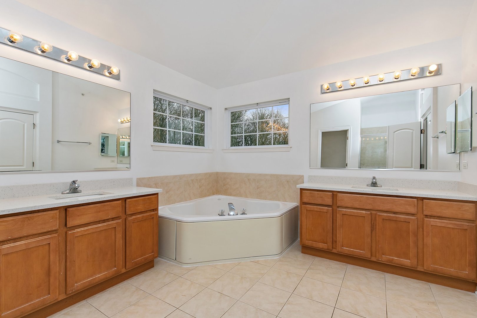 5734 Red Oak Drive Hoffman Estates, IL 60192 - Photo 28 of 31 a bathroom with a tub a sink double vanity and a mirror