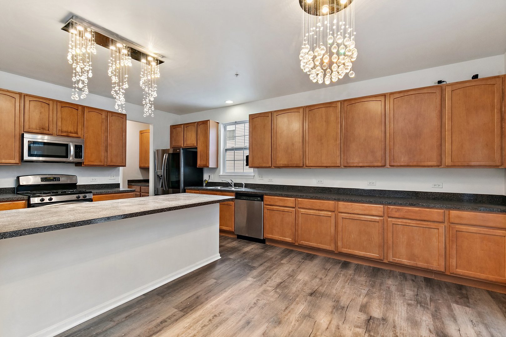5734 Red Oak Drive Hoffman Estates, IL 60192 - Photo 10 of 31 a kitchen with stainless steel appliances granite countertop a sink dishwasher a stove a microwave oven with cabinets and wooden floor