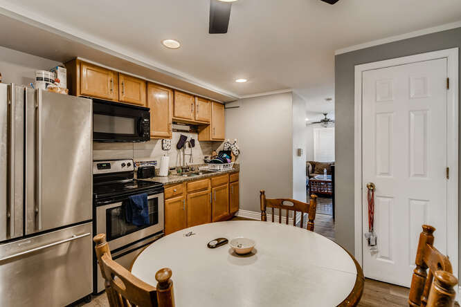 5815 South May Street Chicago, IL 60621 - Photo 21 of 26 a kitchen with stainless steel appliances granite countertop a stove a sink dishwasher a dining table and chairs with wooden floor