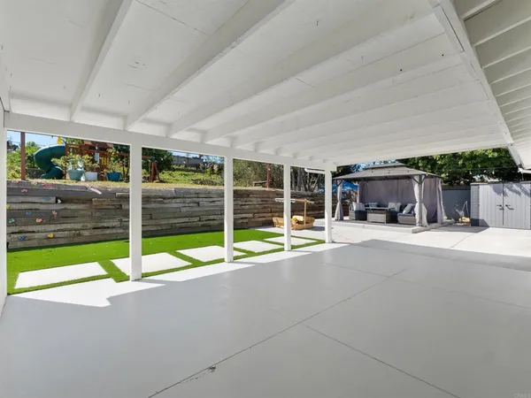 a view of a house with a patio and a yard