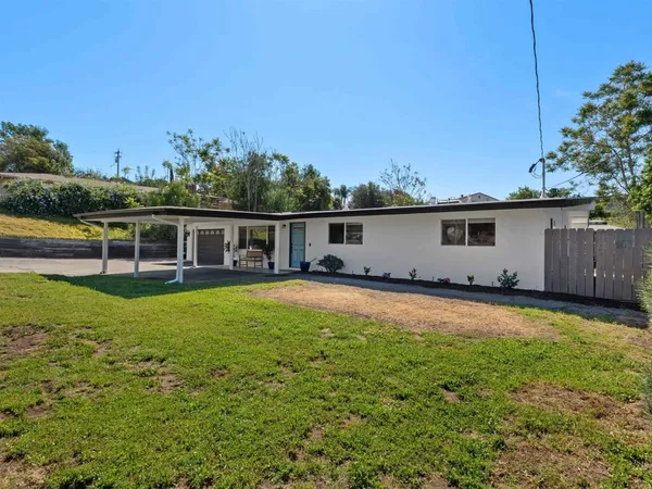 a view of a house with pool and a yard