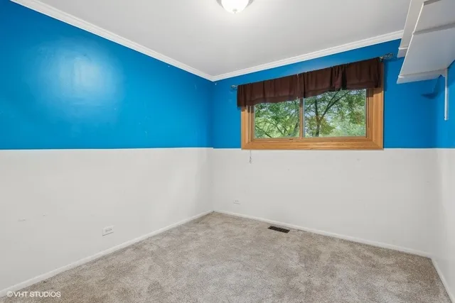 a view of an empty room with a fireplace and a window