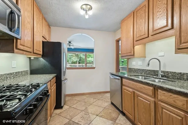 a kitchen with stainless steel appliances granite countertop a stove a sink and a microwave