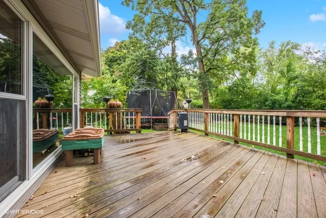 a view of a wooden deck with furniture and trees