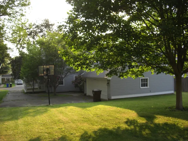 a view of a house with a yard garage and tree