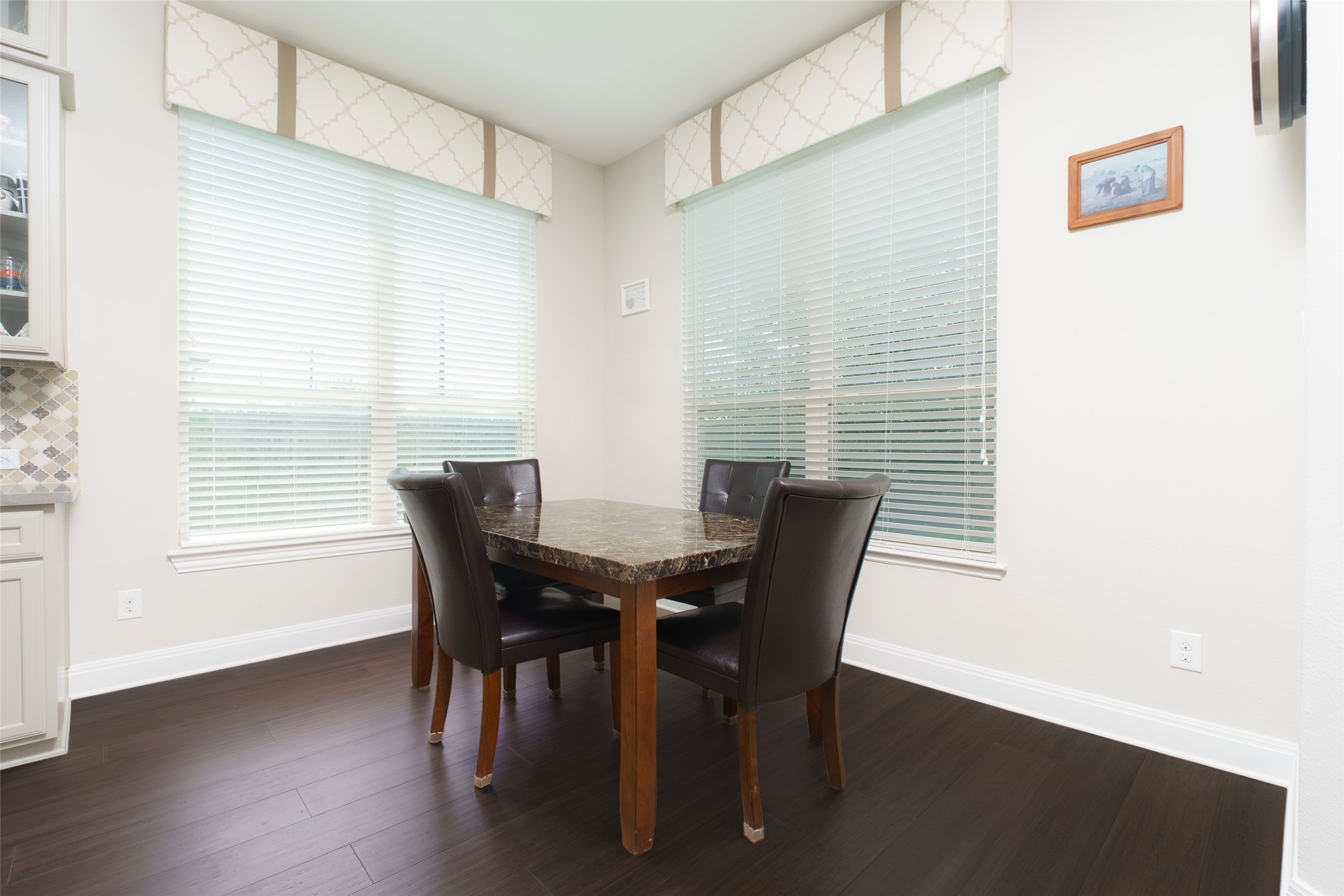 2305 Millbrook Loop Leander, TX 78641 - Photo 23 of 26 Rich hardwood floors complement the natural light streaming through large windows in this cozy dining area.