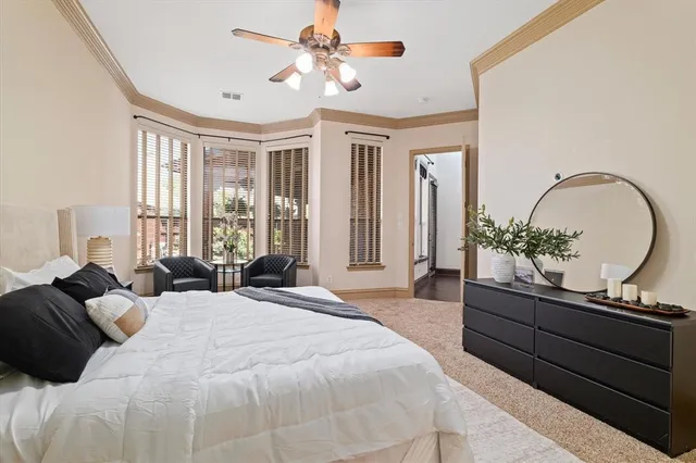 a spacious bedroom with a bed mirror and window