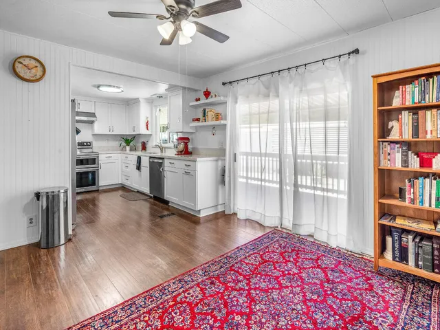 a kitchen with a refrigerator and a wooden floor