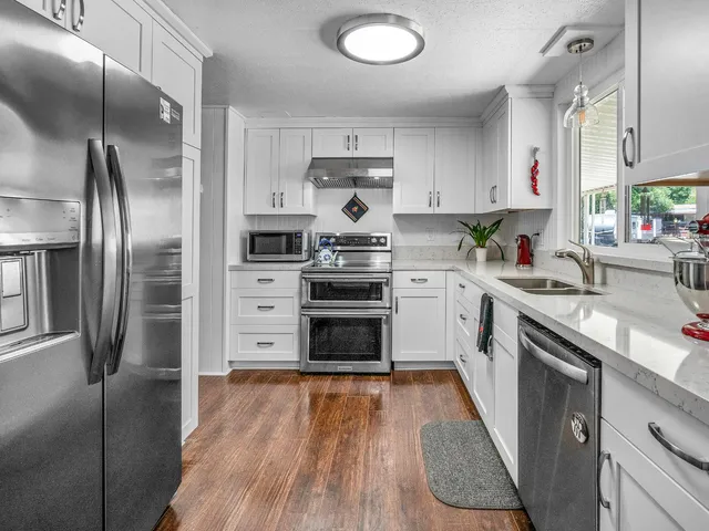 a kitchen with stainless steel appliances a stove sink and refrigerator