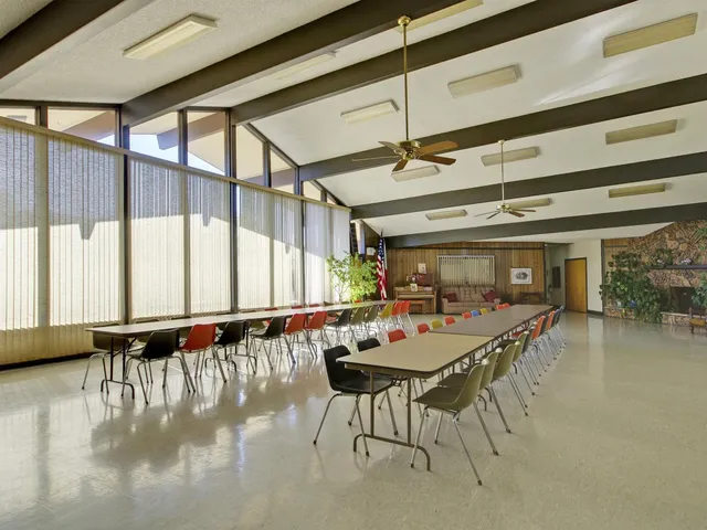 a dining hall with furniture and a large window