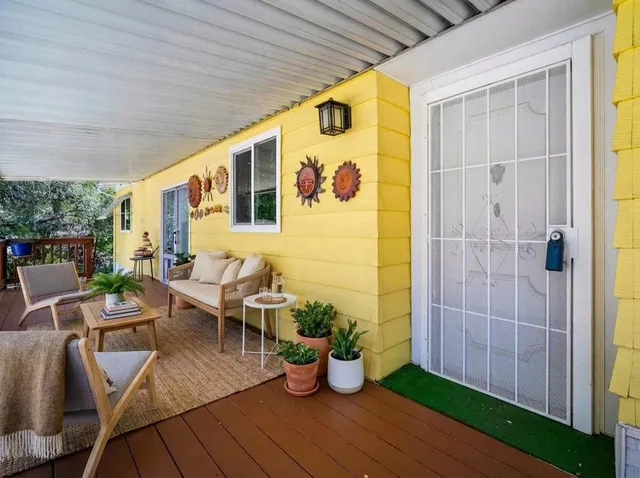 a living room with patio furniture and potted plants