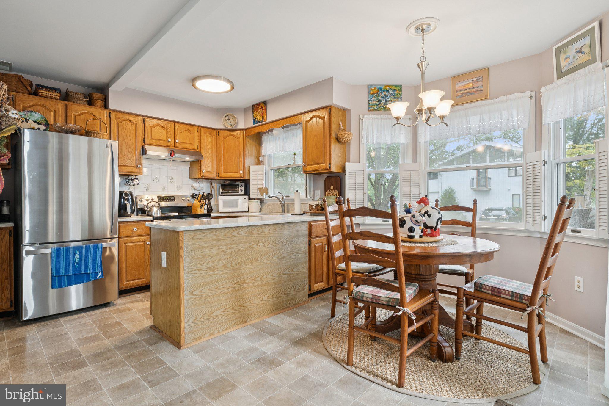 968 Chesapeake Avenue Deale, MD 20751 - Photo 11 of 57 a kitchen with a table chairs refrigerator and cabinets