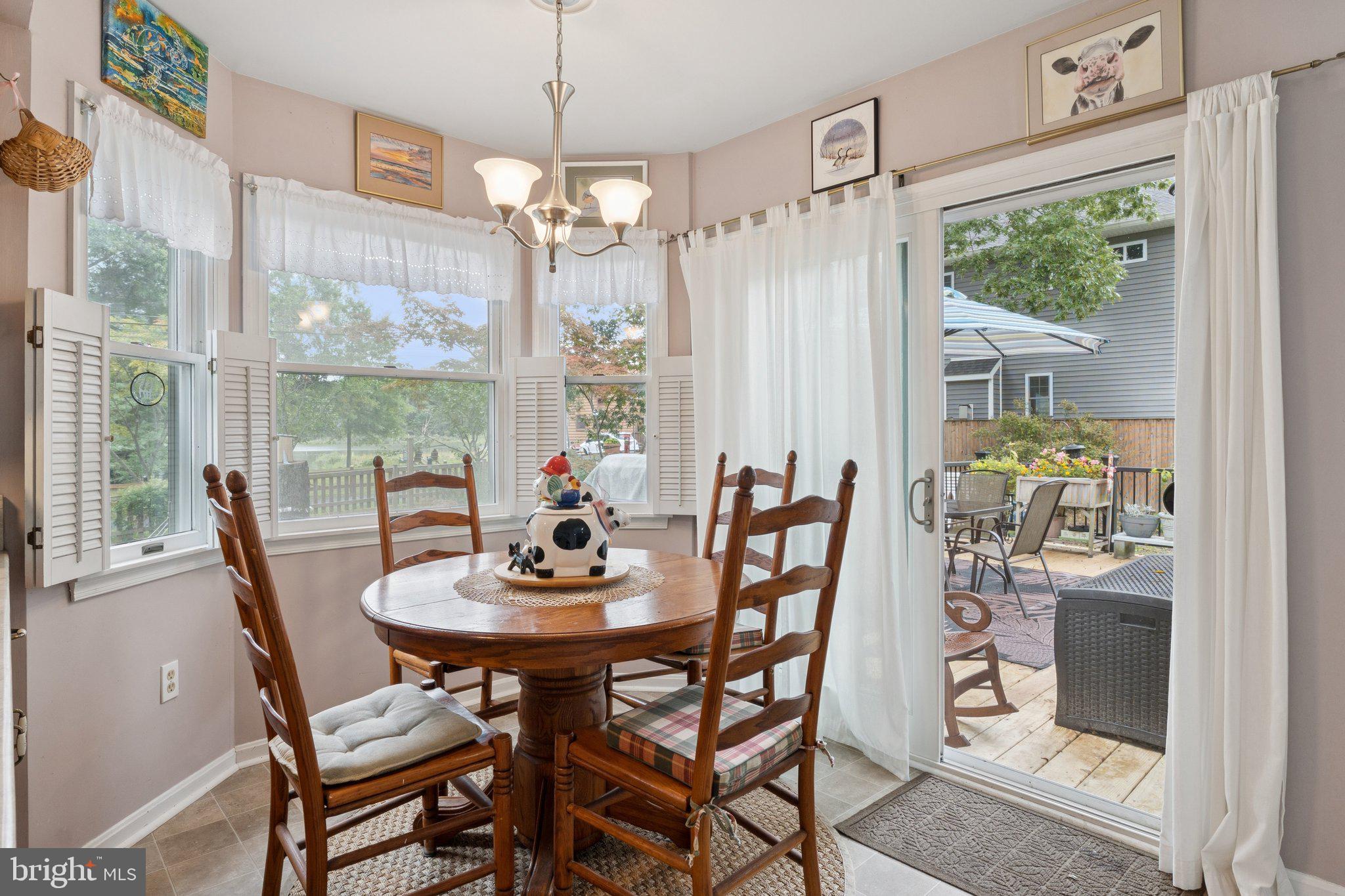 968 Chesapeake Avenue Deale, MD 20751 - Photo 12 of 57 a view of a dining room with furniture a chandelier and wooden floor