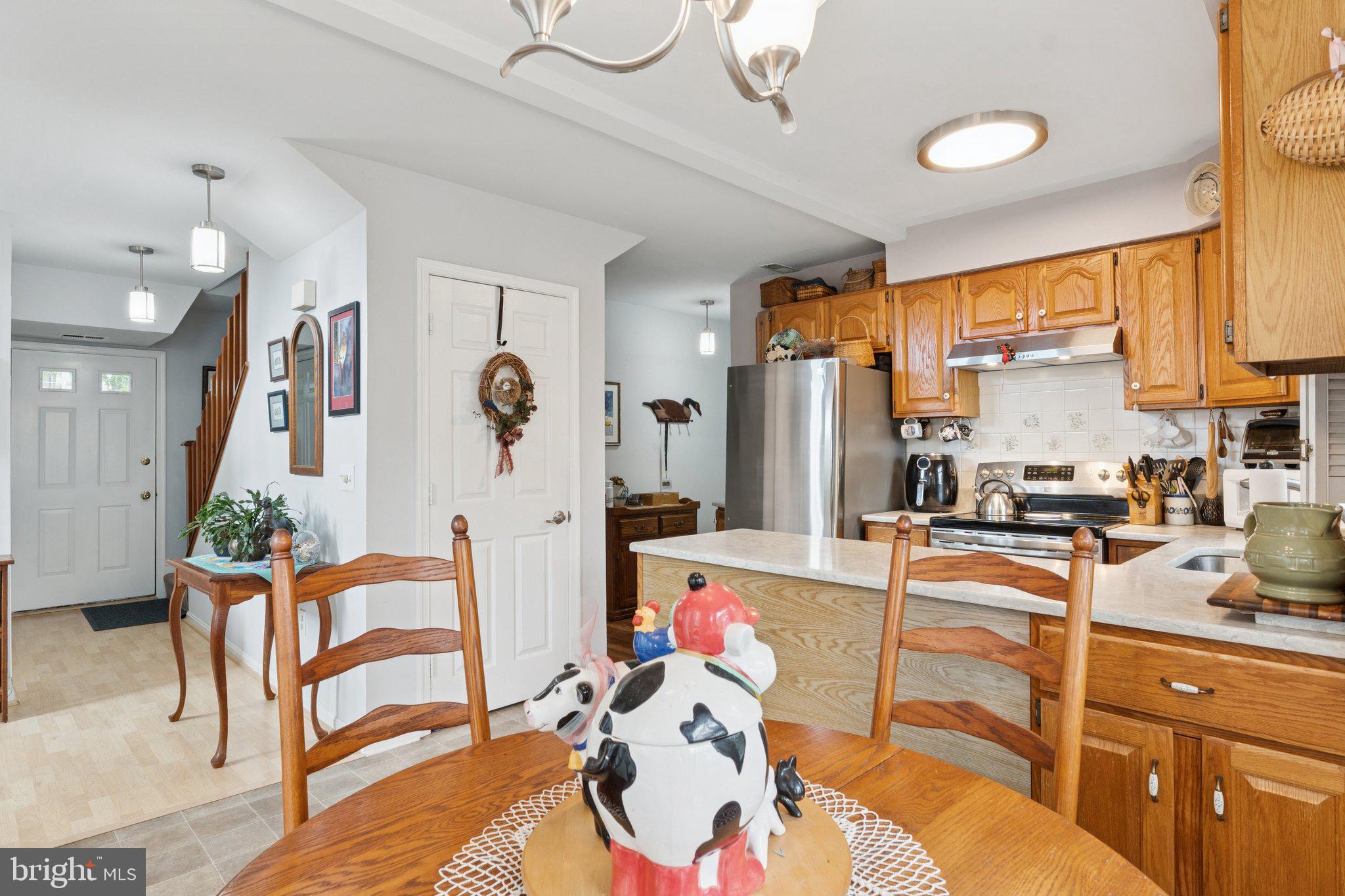 968 Chesapeake Avenue Deale, MD 20751 - Photo 13 of 57 a very nice looking open kitchen with stainless steel appliances granite countertop a stove a refrigerator a dining table and chairs with wooden floor