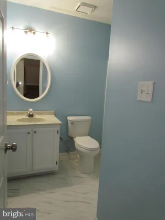 a bathroom with a toilet a sink and mirror