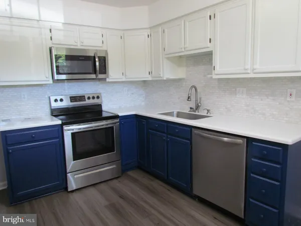 a kitchen with stainless steel appliances granite countertop a sink a stove a microwave and cabinets