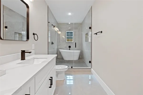 a bathroom with a sink a toilet and a mirror