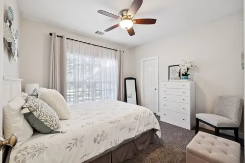 a bedroom with a bed a couch and a large window