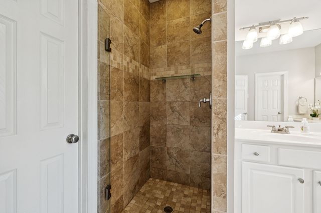 a bathroom with a shower sink and mirror