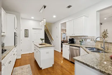 a kitchen with granite countertop a sink stove and cabinets