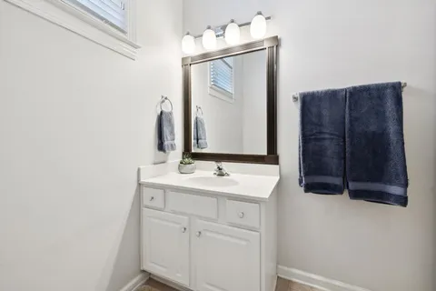 a bathroom with a sink vanity and a mirror