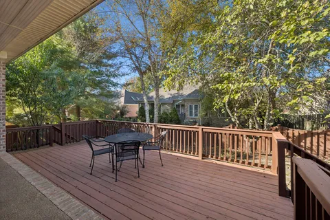 a view of a roof deck with table and chairs and wooden floor