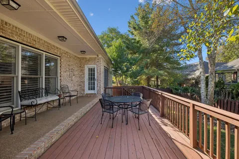 a balcony with wooden floor table and chairs