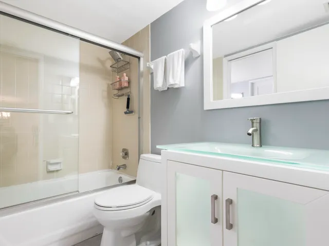 a bathroom with a sink a toilet and shower