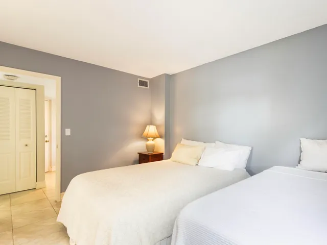 a bedroom with two bed and a night lamp