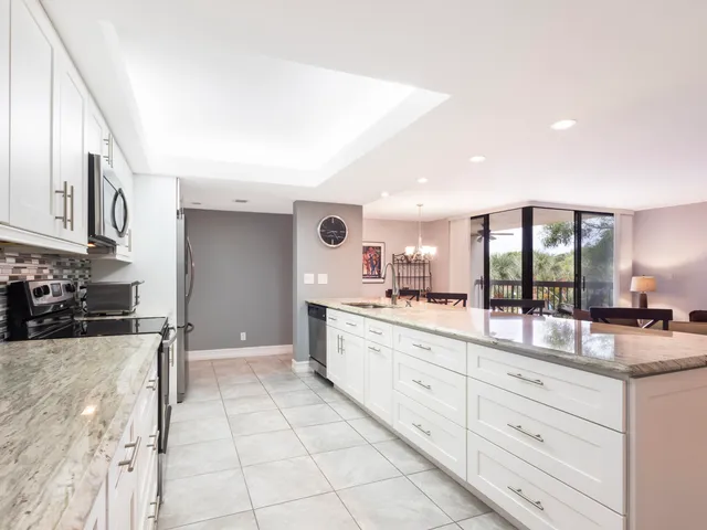 a large kitchen with kitchen island granite countertop a large counter top stainless steel appliances and cabinets