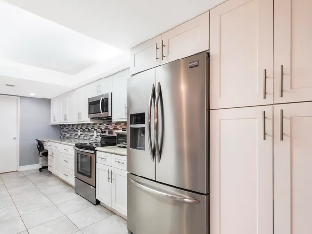 a kitchen with stainless steel appliances a refrigerator and a stove top oven