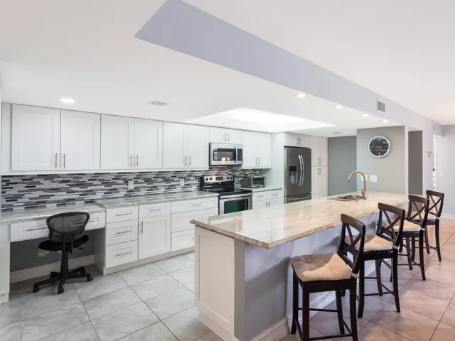 a kitchen with a dining table chairs and refrigerator