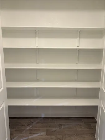 a view of a small space with wooden floor and a window