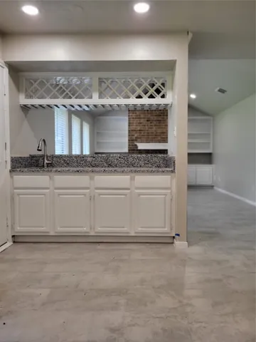 a white kitchen with a sink and cabinets
