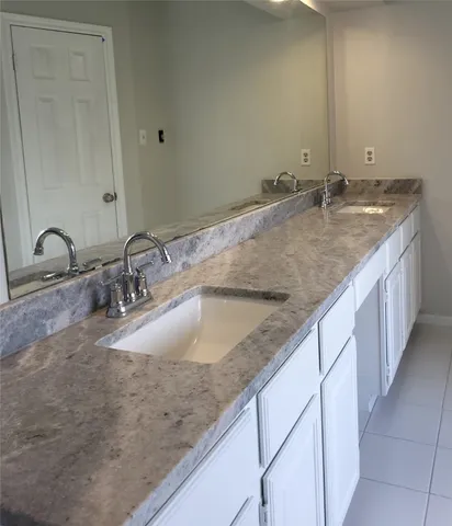 a bathroom with double sink and a mirror