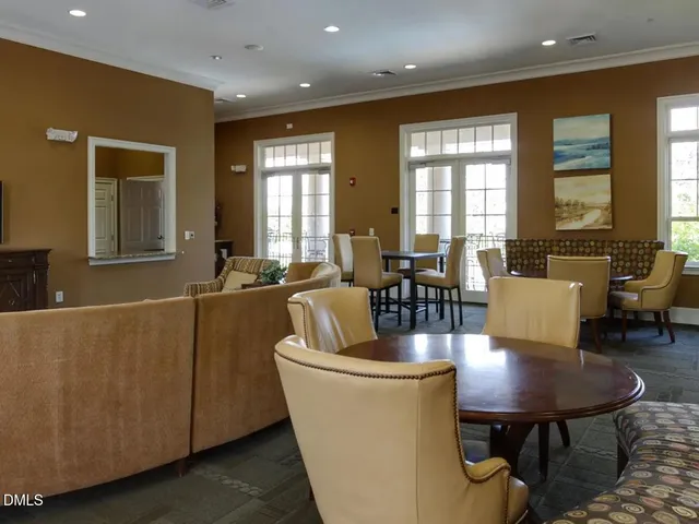 a living room with furniture two window and a dining table