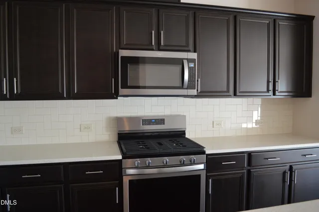 a kitchen with granite countertop cabinets and steel stove top oven